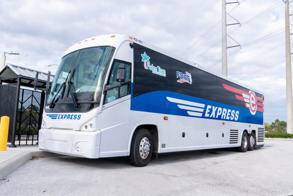 White and blue Express bus parked near a shelter, under a cloudy sky. Logos for transportation services displayed. The mood is calm and professional.