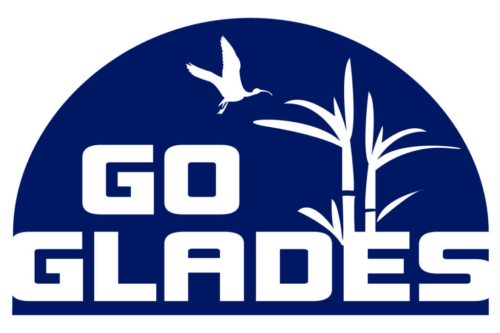 Blue circular logo with "Go Glades" text in bold white letters. A crane flies over stylized grass, evoking a natural, serene tone.