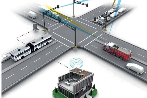 A digital illustration shows a city intersection with cars, a bus, and a fire truck; connected lines depict vehicle-to-infrastructure communication systems linked to a building.
