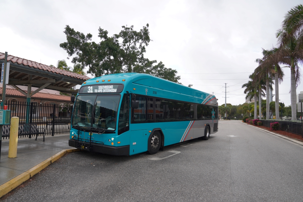 A teal fixed route Palm Tran bus parked at the Intermodal Station in West Palm Beach.